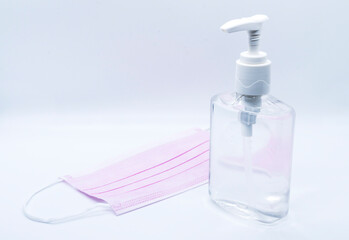sanitizer jel bottle with pink face masks isolated on white background.