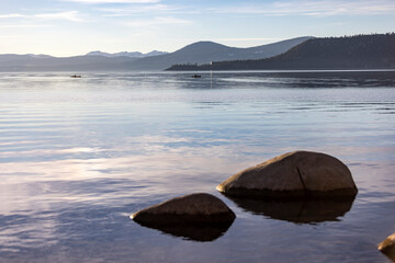 Tiny kayaks in the distance in a photo from the shore of Lake Tahoe