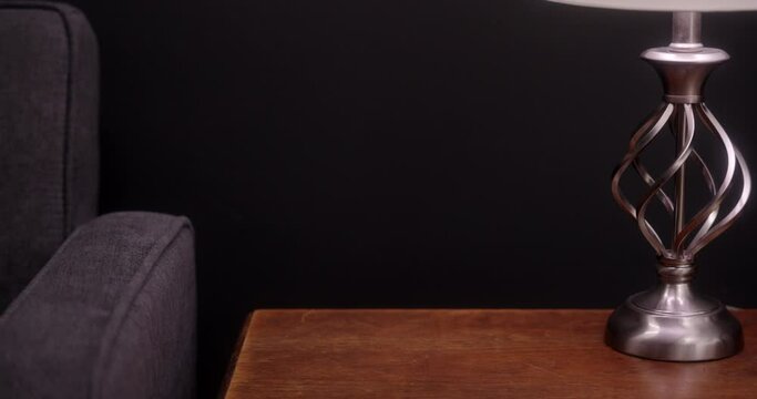 A man picks up a beer from the table.