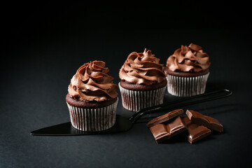 Tasty chocolate cupcakes on black background