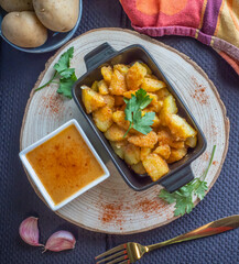 Top view of a tapa of patatas bravas. Ingredients all around. Typical Spanish food.