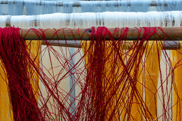 White, red and yellow silk threads for Persian carpet weaving