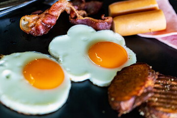 fried eggs with bacon, sausages and toasts
