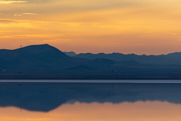 Reflection of the sunset and the mountain in the salt lake
