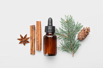 Fototapeta premium Bottle of essential oil, spices, fir branch and cone on white background