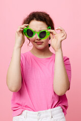 Stylish teenager girl model in a pink T-shirt green glasses Youth fashion