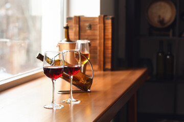 Glasses of wine and bottle on window sill