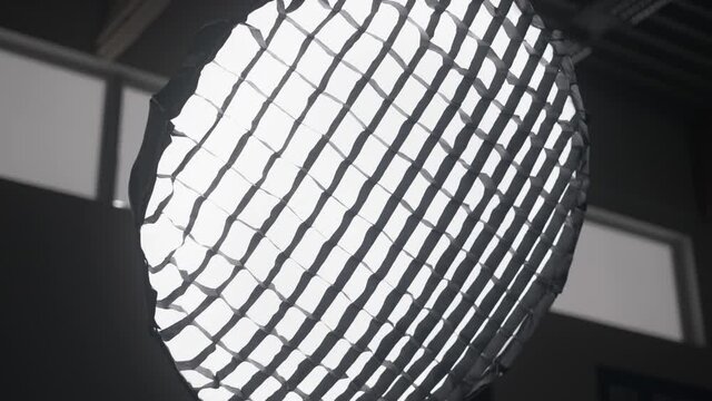 Orbit medium shot of parabolic softbox strobe light in studio