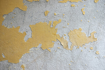 Peeling paint on old wall background abstract texture pattern.Concrete cement cracked, rough surface yellow.
