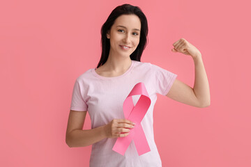 Young woman with ribbon on pink background. Breast cancer awareness concept