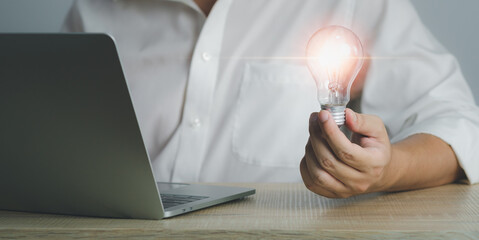 close up of businessman sit at desk hold light bulb inspired by innovative business idea, male boss or director motivated with successful startup in office, innovation, energy save concept