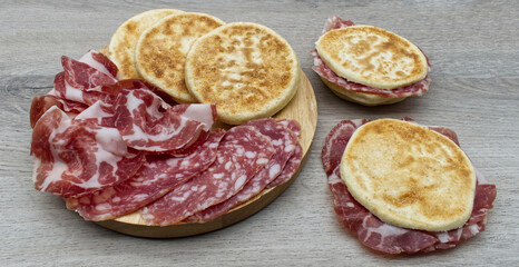 Delicious Italian Tigelle on wooden background. Traditional dish from Emilia-Romagna region. Bologna, Italy
