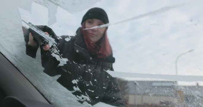 Winter Driving - Scraping ice off the frozen windshield of a car - slow motion - ProRes

A hand-held slow-motion shot, showing a young woman clearing the frozen windshield of her car from ice