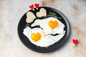 valentines day fried egg breakfast on the table scrambled eggs heart shape holiday decoration love date copy space food background