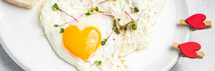 valentines day fried egg breakfast on the table scrambled eggs heart shape holiday decoration love date copy space food background