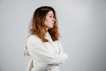 Close-up portrait of insane woman in straitjacket on white background.