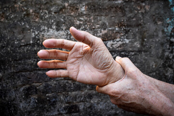 Hand of Asian elder man. Concept of joint pain, arthritis or hand problems.