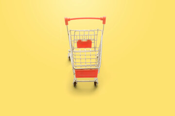 shopping trolley on yellow background with some copy space.