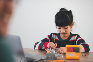 Inventive kid constructing robot cars at home