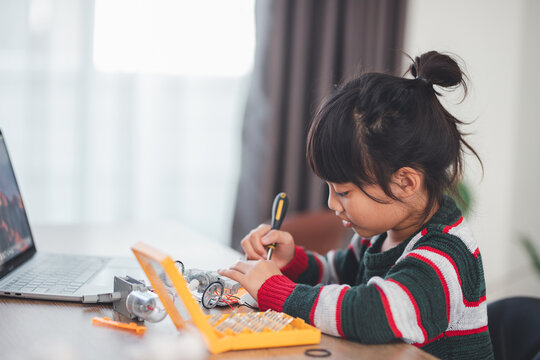 Inventive kid constructing robot cars at home