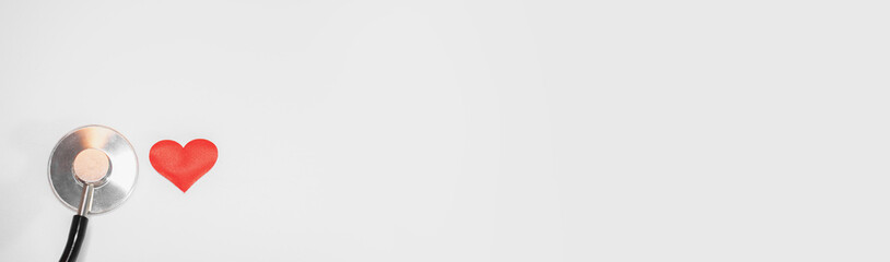 Small kid or child red heart and stethoscope on white background with place for text, top view: cardiologist's day, international Day of Medicine, blood donor, crop. Health and Medical banner