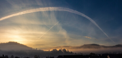 Sonnenaufgang &uuml;ber einer klein Stadt im Herbstnebel