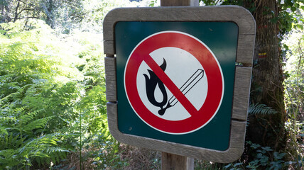 No open fire burning symbol in wooden panel outdoor park Match with flame in red crossed circle