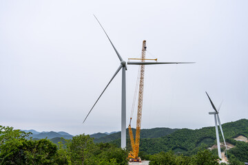 Construction of a wind power generator for renewable energy, Turbine hangs on crane hook at wind...