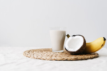 white healthy smoothie made of banana and fresh coconut, in a glass glass. healthy breakfast, healthy lifestyle