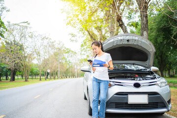 Asian woman calling for assistance with his car broken down by the roadside. She called the...
