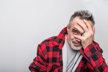Portrait of a cringe man in a warm buffalo check lumberjack shirt