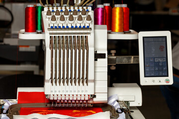 Programmable multicolored thread embroidery machine at work. Close-up. Copy space.