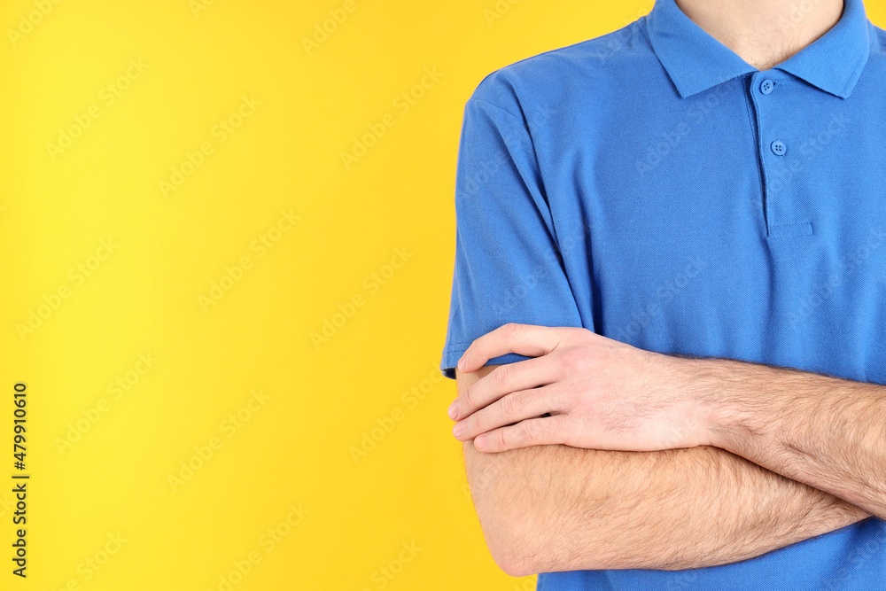Wall mural Man in blank blue polo on yellow background - Wall murals