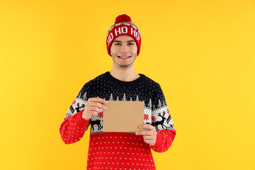 Guy in Christmas sweater with space for text on yellow background