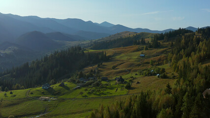 Obraz premium Lonely buildings mountain valley view beautiful green rocky peaks sky background