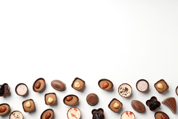 Flat lay composition with chocolate candies on white background