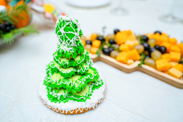 Gingerbread in the form of a Christmas tree with green glaze on a New Year's table 