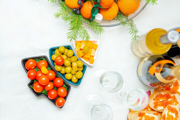 Festive snacks with olives, cherry tomatoes and cheese in plates in the shape of a Christmas tree. Top view, banquet