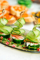 Festive canapes with salmon and cucumber in the form of a Christmas tree on a family holiday table....