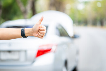 Close-up of woman's hand, Asian young woman opened the hood broken car on the road Searching for help The car is coming.