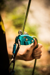 Man's hands operating a rock climbing belaying device