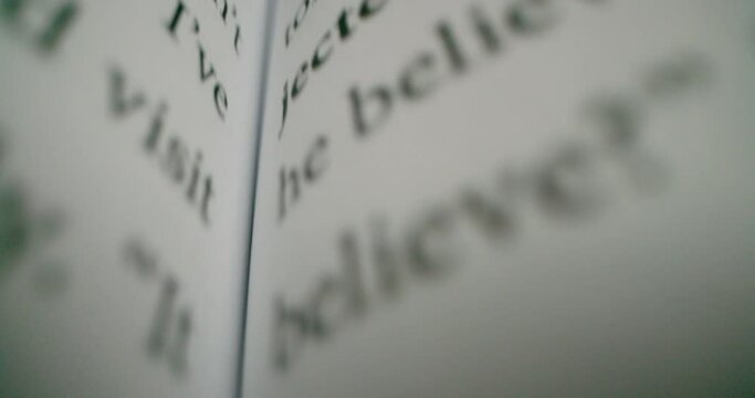 An open book very closely. Macro footage of words on page.