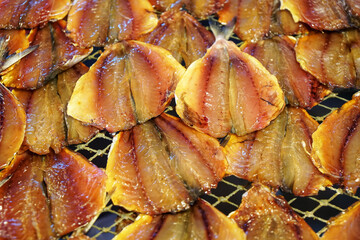 Group of dried salt fish. Many pieces arranged in basket for sell in market.