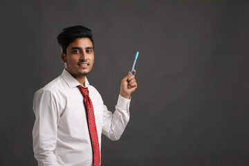 Young indian man showing expression on dark background.