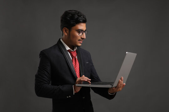 Young indian banker or officer using laptop
