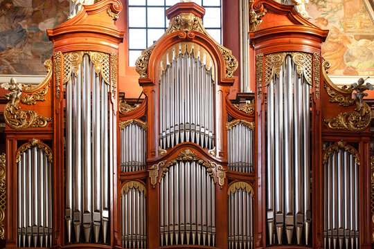 The organ in the Baroque parish church in Poznan, Poland. Fragment of the instrument, silver pipes and wooden ornaments.