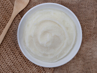 Traditional South African Maize meal porridge on rustic background with burlap and wooden spoon and copy space