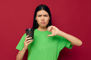 woman in a green t-shirt black glass with a drink displeasure