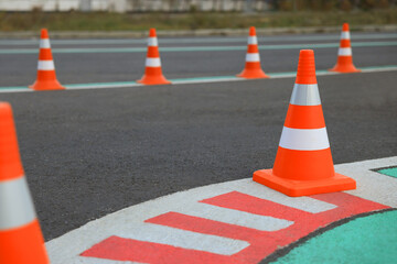 Driving school test track with marking lines, focus on traffic cone
