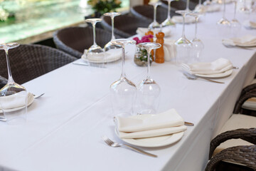 Tables set for meal. Plate, wine glasses and cutlery on a banquet server table with a white tablecloth in a luxury restaurant
